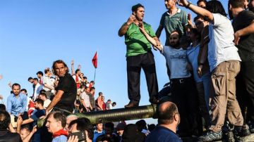 Un grupo festeja el fin del intento de golpe de Estado sobre un tanque.