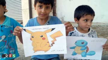 Niños sirios sostienen carteles con fotos de Pokémon y un mensaje "Soy de Siria, sálvame".