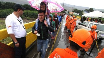 Miles de venezolanos sortearon las lluvias para cruzar la frontera entre Venezuela y Colombia este domingo.