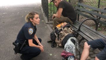 Una agente del NYPD habla con visitantes del parque ompkins Square Park, en Manhattan.