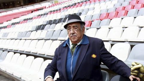 Melquiades Sánchez Orozco, la voz oficial del Estadio Azteca, posa con "Nachito", estatua localizada en uno de los asientos como monumento a los aficionados.