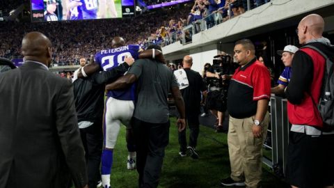 Adrian Peterson, corredor estrella de los Vikings, tuvo que ser ayudado para abandonar el campo el domingo en la noche durante el juego contra Green Bay con una lesión de rodilla.