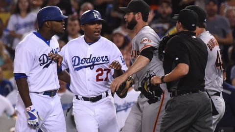 Yasiel Puig le reclama a Madison Bumgarner, quien tuvo que ser bloqueado en un altercado entre Dodgers y Gigantes que estuvo cerca de provocar una pelea campal.