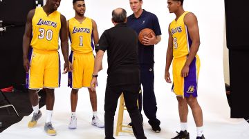 Los jugadores de los Lakers (de izq. a der.) Julius Randle, D'Angelo Russell y Jordan Clarkson se acomodan con su nuevo entrenador Luke Walton para una sesión de fotos en el día de medios del equipo.