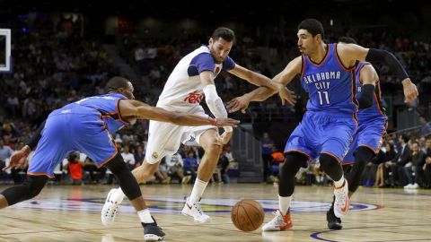 El alero del Real Madrid, Rudi Fernández intenta superar la defensa de los jugadores del Oklahoma City Thunder, Russell Westbrook y el pivot turco Enes Gulen.