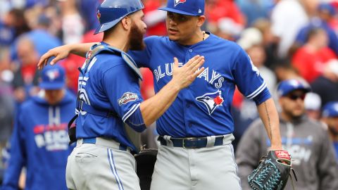 Russell Martin felicita al cerrador Roberto Osuna tras ganar el segundo juego de la serie.