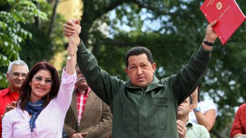 Venezuelan President Hugo Chavez (R) holds up the minutes of the constitutional amendment handed in by the president of the National Assembly Cilia Flores (L) on February 19, 2009 in Catia, a poor neigborhood west of Caracas. Chavez enacted Thursday the amendment approved Sunday in a referemdum, which will allow indefinite re-election in Venezuela. AFP PHOTO/Pedro REY (Photo credit should read PEDRO REY/AFP/Getty Images)