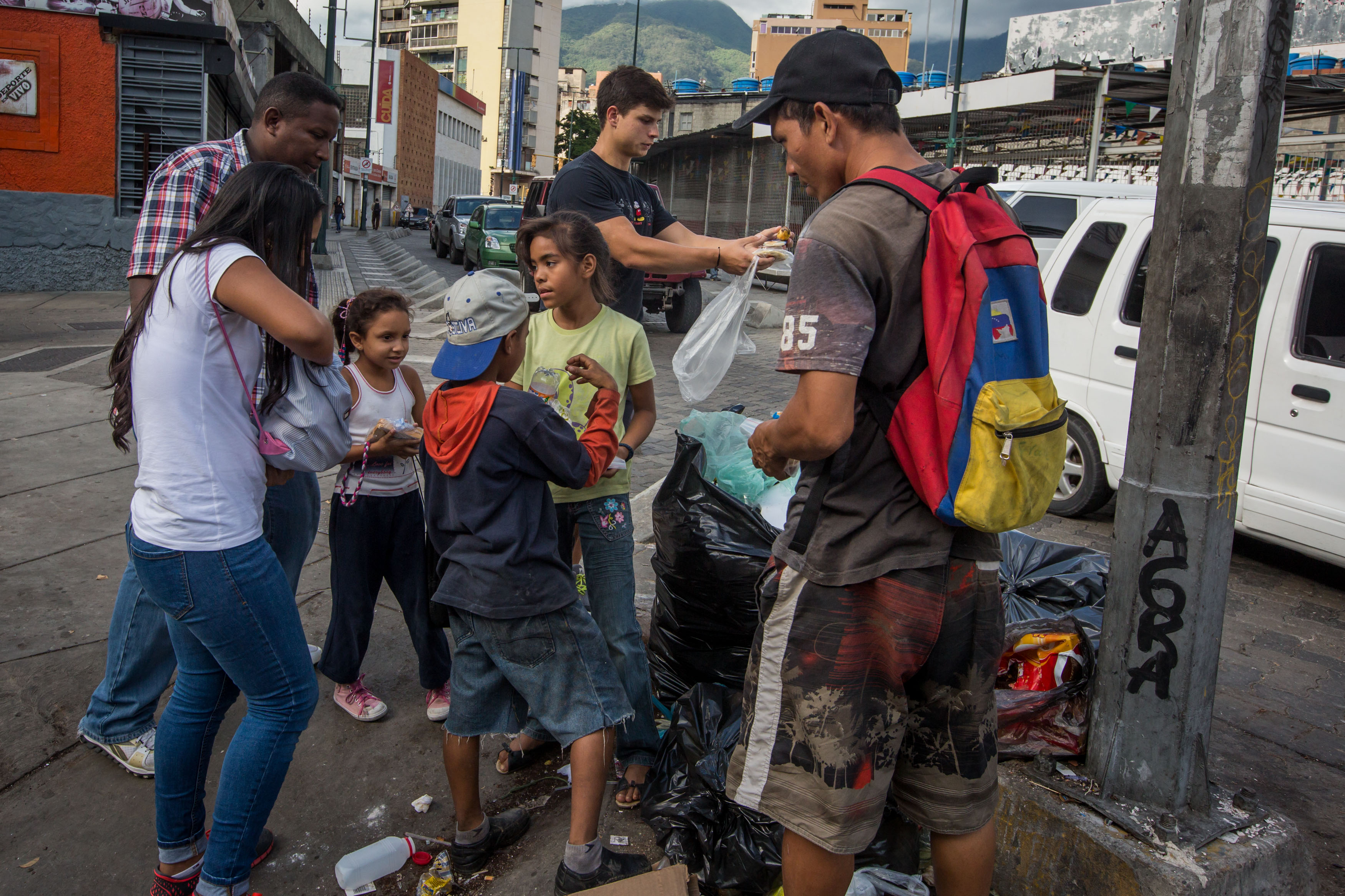 Un grupo reparte comida comprada y preparada por ellos mismos, a personas en situación de indigencia, en Caracas. 