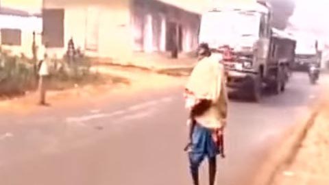 Los vehículos pasan de largo al costado del hombre.