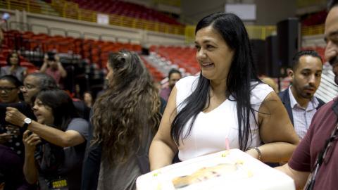 Clarisa sonríe mientras posa con un bizcocho de cumpleaños con la imagen de su papá, el conmutado Oscar López.