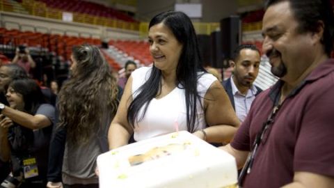 Clarisa sonríe mientras posa con un bizcocho de cumpleaños con la imagen de su papá, el conmutado Oscar López.