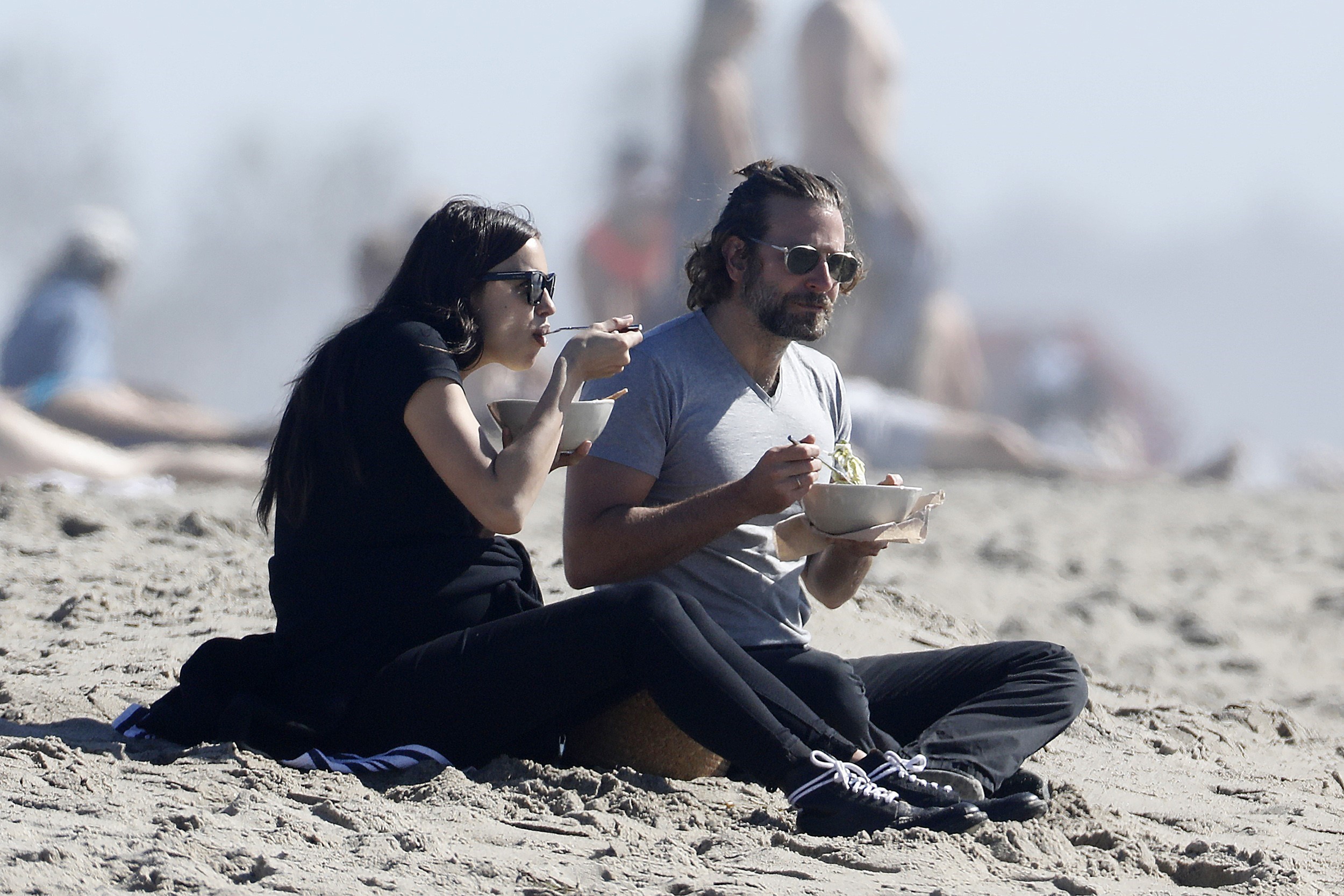 Photo © 2017 AKM GSI/The Grosby Group PREMIUM EXCLUSIVE Los Angeles, February 14, 2017. Bradley Cooper and Irina Shayk bring their own lunch to the beach and cuddle after enjoying their meal. The couple look sweet and in love as Bradley helps Irina stand up so they can leave hand in hand.