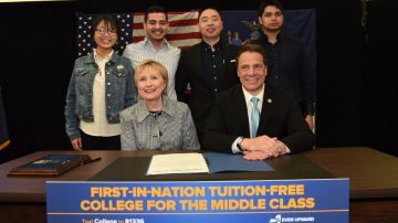 Hillary Clinton, y jóvenes que se beneficiarán, acompañaron al gobernador Andrew Cuomo en la firma de la ley.
