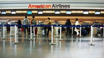 Viajeros en la terminal de American Airlines del aeropuerto John F. Kennedy de Nueva York que a partir de agosto no ofrecerá viajes a San Juan, Puerto Rico.