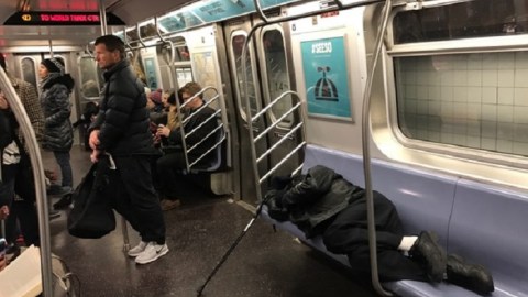 Los vagones del tren E se vacían cuando un desamparado ocupa el servicio.