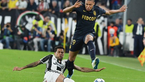 El jugador de la Juventus, Dani Alves (izquierda), marca a Kylian Mbappé (derecha), del Mónaco.