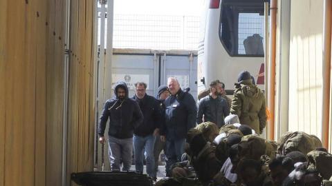 Inmigrantes nigerianos esperan el pasado martes a que varios autobuses los trasladen desde el "punti di crisi" de Pozzallo, vigilado por agentes italianos y europeos de la agencia Frontex.