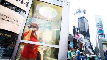 Una mujer escucha una historia grabada de un inmigrante neoyorquino en una de las tres cabinas telefónicas en Times Square que forman parte de la instalación artística 'Once Upon a Place' .