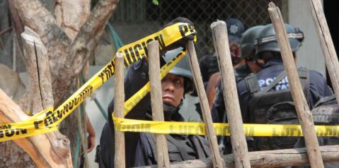 Policías custodian una de las residencias atacadas.