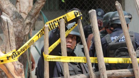 Policías custodian una de las residencias atacadas.