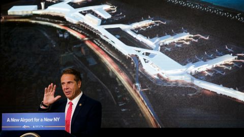 El gobernador Andrew Cuomo frente a una imagen de fondo de las nuevas instalaciones durante la ceremonia de inauguración de las nuevas instalaciones de Delta Airlines.