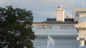 Manifestantes en el exterior de la Casa Blanca protestan contra la violencia racista reportada en Virginia.
