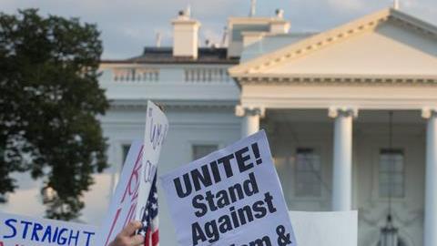 Manifestantes en el exterior de la Casa Blanca protestan contra la violencia racista reportada en Virginia.