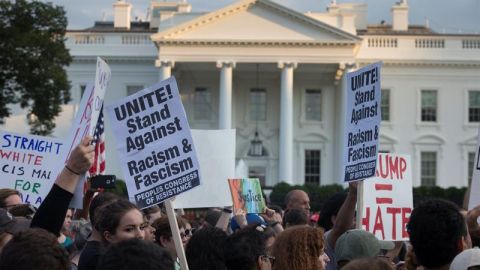 Manifestantes en el exterior de la Casa Blanca protestan contra la violencia racista reportada en Virginia.