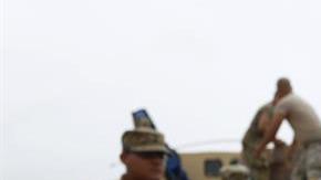 Un niño con una camiseta que lee 'Nunca nos quitamos' recibe una caja de alimentos entregada por miembros del Ejército en Las Piedras.