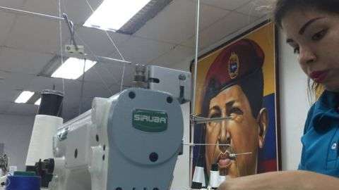 Un gran mural de Hugo Chávez gobierna el taller textil de la comuna Panal 2021.