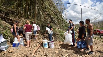 Residentes del pueblo de Naranjito, al suroeste de San Juan, se aprovisionan de agua de un manantial creado por los deslizamientos de tierra.