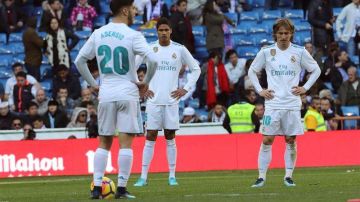 Los jugadores del Real Madrid, Marco Asensio, Raphael Varane y Luka Modric se lamentan tras el tercer gol del FC Barcelona en el Clásico. (Foto: EFE/Kiko Huesca)