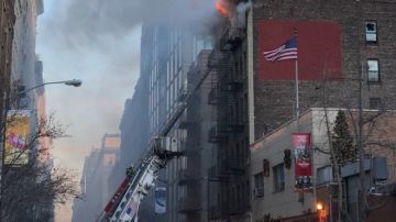 Las llamas se ven saliendo del último piso del 144 de la calle 19 Oeste.