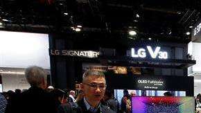 Personas observan un televisor del stand de LG durante el Salón Internacional de la Feria de Electrónica de Consumo.