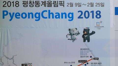 Varios ciudadanos pasan junto a un anuncio de los Juegos Olímpicos de Invierno de PyeongChang 2018 en una estación de Seúl. EFE