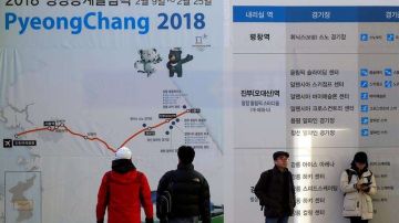 Varios ciudadanos pasan junto a un anuncio de los Juegos Olímpicos de Invierno de PyeongChang 2018 en una estación de Seúl. EFE