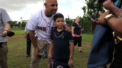 El manager de los Medias Rojas de Boston el puertorriqueño Alex Cora posa con un niño en el sector La Mesa en Caguas, cerca de San Juan, Puerto Rico. (Foto: EFE/Jorge Muñiz)