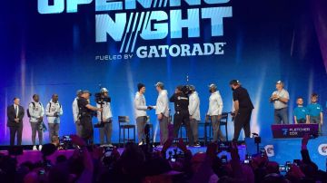 Tom Brady y Nick Foles, los quarterbacks de Patriots y Eagles, se saludan la noche del lunes junto a otros integrantes de ambos equipos durante el 'Opening Night' del Super Bowl en Minnesota.