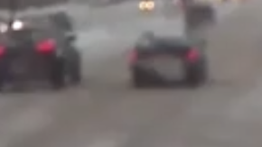 Una mujer en muletas cae al piso cruzando la carretera nevada y un conductor corre a salvarla.