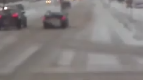 Una mujer en muletas cae al piso cruzando la carretera nevada y un conductor corre a salvarla.