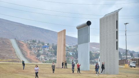 Turistas junto a prototipos del Muro Fronterizo