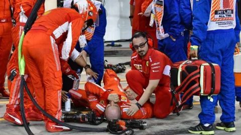 El mecánico de Ferrari Francesco Cigarini  yace en el piso tras una parada en pits de Kimmi Raikkonen durante el Grand Prix de Baréin de Fórmula 1. (Foto: EFE/EPA/GIUSEPPE CACACE / POOL)