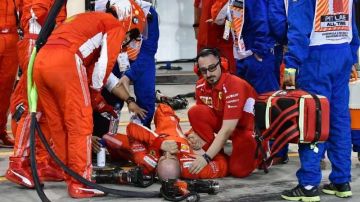 El mecánico de Ferrari Francesco Cigarini  yace en el piso tras una parada en pits de Kimmi Raikkonen durante el Grand Prix de Baréin de Fórmula 1. (Foto: EFE/EPA/GIUSEPPE CACACE / POOL)