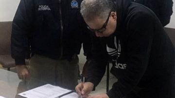 El ex jefe paramilitar firmando sus documentos en Interpol antes de salir de Bogotá a NY