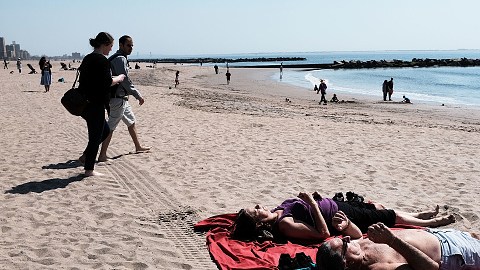 NEW YORK, NY - APRIL 14:  People relax along the beach at Coney Island on a spring afternoon on April 14, 2018 in New York City. Following weeks of cold, snow and ice, New Yorkers got a taste of spring today with mild temperatures and blue skies. Cold weather is expected to return on Sunday.  (Photo by Spencer Platt/Getty Images)