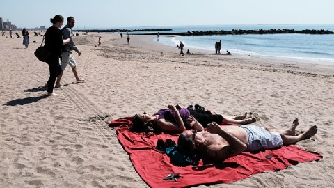 NEW YORK, NY - APRIL 14: People relax along the beach at Coney Island on a spring afternoon on April 14, 2018 in New York City. Following weeks of cold, snow and ice, New Yorkers got a taste of spring today with mild temperatures and blue skies. Cold weather is expected to return on Sunday. (Photo by Spencer Platt/Getty Images)