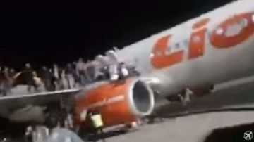 Los asustados pasajeros saltaron desde las alas del avión.