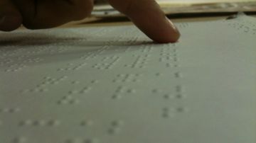 Persona leyendo en Braille.