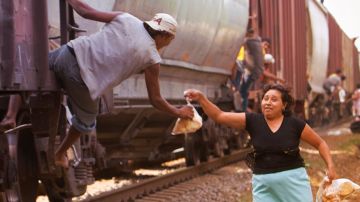 Bernarda Romero, integrante de "Las Patronas" entrega comida a los migrantes centroamericanos que viajan sobre el tren