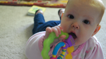 Un bebé muerde un producto para aliviar el desarrollo de su dentadura